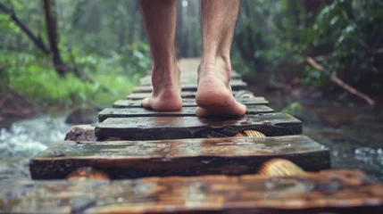 Fototapeten Bare feet on a wooden pathway in a lush forest, embodying natural exploration © kitinut