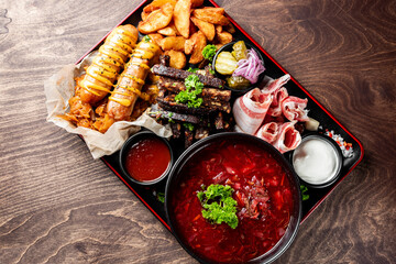 delectable platter of assorted appetizers, including grilled meat, soup, sausages, fries, and dips,...