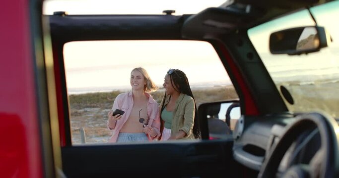 Young African American woman and Caucasian woman are taking a selfie inside a car on a road trip