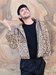Young man with a funny  facial expression wearing leopard hoodie on a marble background.