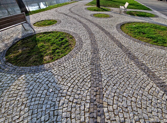 stepping stones lead to a small circular lawn in the middle of a flower bed. sitting on a bent...