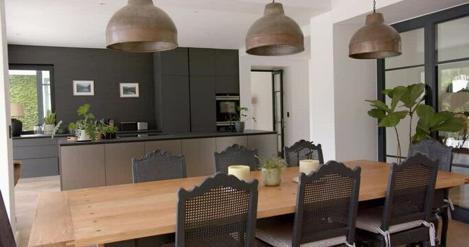 A modern kitchen with a wooden dining table and black chairs