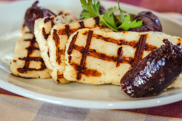 Grilled Halloumi - traditional Cypriot cheese and sausages on a plate in Cyprus