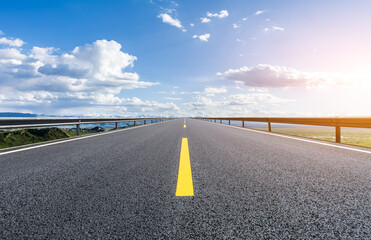 Straight asphalt road with sky clouds nature background