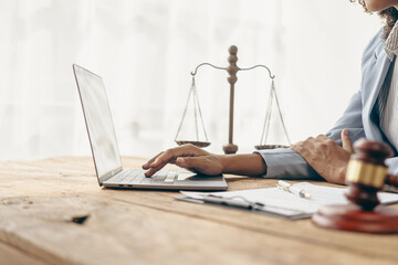 Female lawyer working in office or court with hammer and scale, justice on table, online legal...