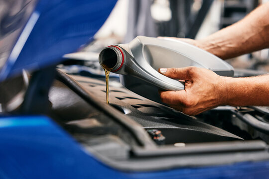 Fototapeta Close-up of car mechanic changing oil in car engine