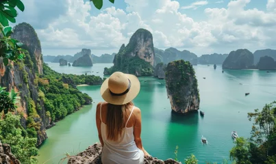 Selbstklebende Fototapeten Woman admiring the natural beauty of Phang Nga Bay surrounded by lush greenery and crystal clear water © AlfaSmart