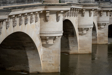 Obraz premium Paris, France - 03 08 2024: The quays of the Seine. View detail of Le Pont Neuf with stone sculptures and pillars.