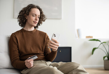 Man holding credit card and using smartphone at home, businessman shopping online, e-commerce, internet banking, spending money, working from home concept