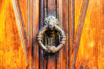 Ancient door knocker in wood door