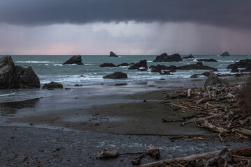 A rocky beach with a stormy sky in the background