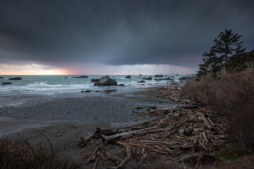 A rocky shoreline with a stormy sky in the background