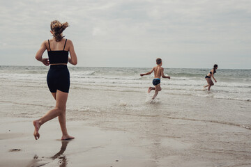 Kinder rennen vom Strand in das Meer (Domburg, Zeeland, Niederlande)