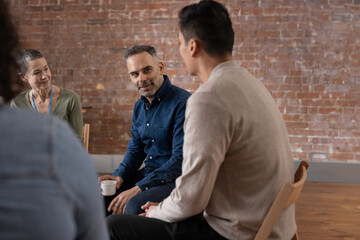 Mature man sharing his story in a group therapy session