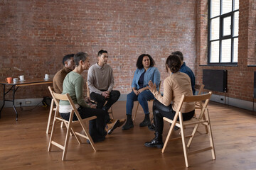 Group of diverse adults sitting in a circle discussing ideas together