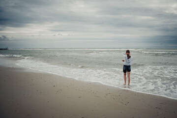 Mädchen schaut am Strand bei Domburg auf das Meer hinaus