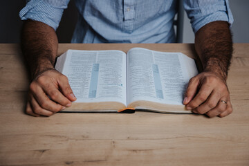 Man is ready to read the bible in a low light environment