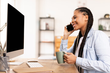 Smiling african american lady student with coffee mug on phone call