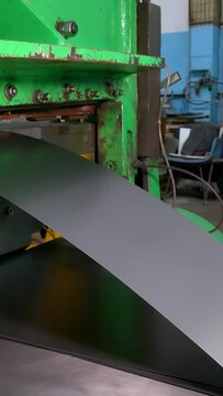 Stamping of sheet steel parts on a hydraulic press. Stamping on the press. Rolls of sheet steel for press forming of products in the factory. Steel sheet in coils.