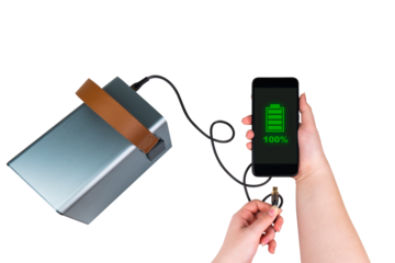 Smartphone in one hand and a USB cable in other hand are connected to a power bank (charging station) on a transparent background. On smartphone screen - green battery indicator 100% (full charge)