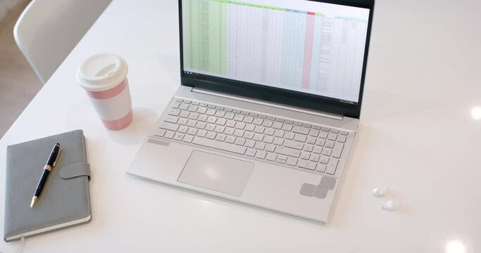 A modern business laptop on a white desk in an office setting