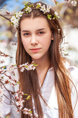 Naklejka premium Young beautiful woman in a blooming garden