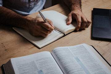 Man is ready to study the Bible and make notes in his notebook