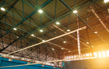 Bottom view of volleyball net in school sport gym. Backdrop sports image of volleyball court with...