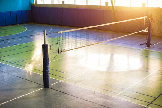 Top view of volleyball court with net in school gym. Backdrop sports image of volleyball courts in sport hall. Concept of team game, active match, healthy lifestyle, team success. Copy ad text space