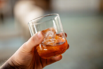 A man holds a classic Negroni cocktail with ice. - 757349538