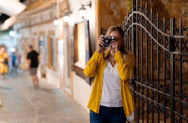 Woman tourist with vintage camera in the old town. - 757349545