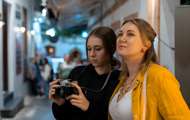 Two girls with retro camera exploring old city. - 757349571