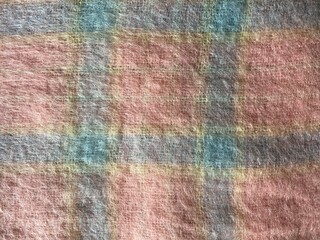 Mohair. Pink wool mohair scarf with fringe. warm knitted blanket with pink and blue geometric pattern. Texture wool