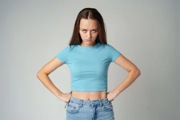 Rolgordijnen Portrait of sad displeased offended young woman in blue T-shirt on gray background © fotofabrika