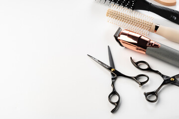 Black hairdressing tools and various hairbrushes on white background
