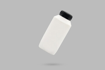 White blank plastic fresh milk bottle with black cap floated on gray background