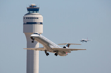 Commercial Airliners Taking Off and Landing  at a Busy Airport with Control Tower