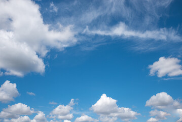 blue sky background framed with cumulus and cirrus clouds.