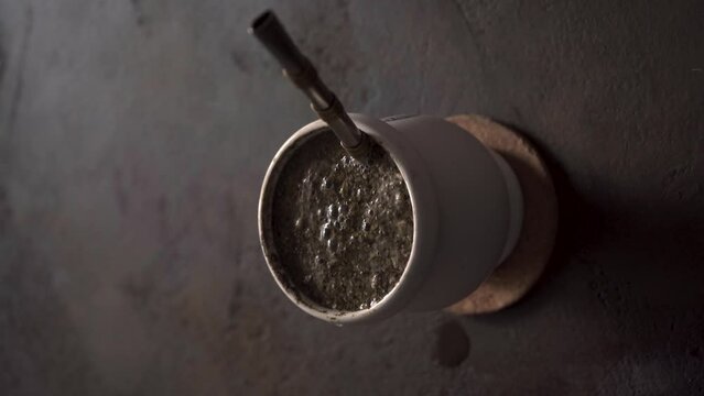Yerba mate drink. Pouring water to yerba mate drink. Vertical view