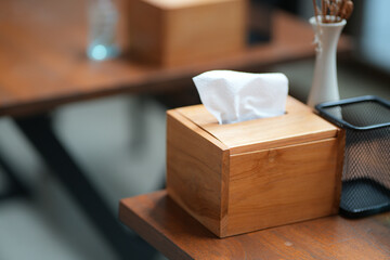 Close up and selective focus tissue paper in wood box on wooden table in kitchen or dining room.