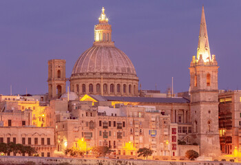 Obraz premium St John's Cathedral on the Valletta waterfront at sunset.