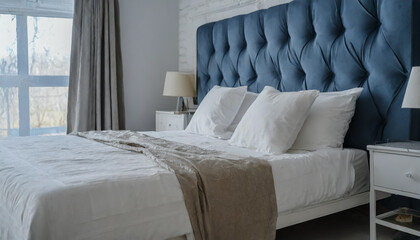 On a blue bed are white pillows, a duvet, and a duvet cover. On top of a blue sofa is a white bed. Bedroom mock up on the wall with a bed, bedding, and poster frame. looking left. - obrazy, fototapety, plakaty