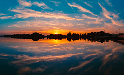 High resolution stitched summer sunset panorama with reflections near Plattling, Isar, Bavaria,...