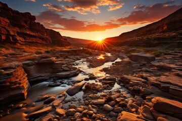 The sky is ablaze with the setting sun over a river in a canyon
