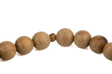 Close-up on grains of wooden prayer rosary isolated on white background.