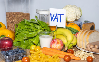 Food products and a sign with the inscription Vat (tax in Polish) Concept, Restoration of VAT on...