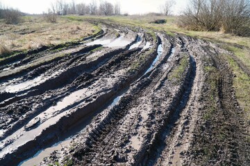 Dirty impassable country road with deep ruts
