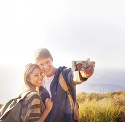 Foto op Plexiglas Phone screen, selfie and hiking couple hug in nature for photography, memory or blog profile picture. Smartphone, app and people outdoor with love, happy or smile for social media travel vlog update © peopleimages.com