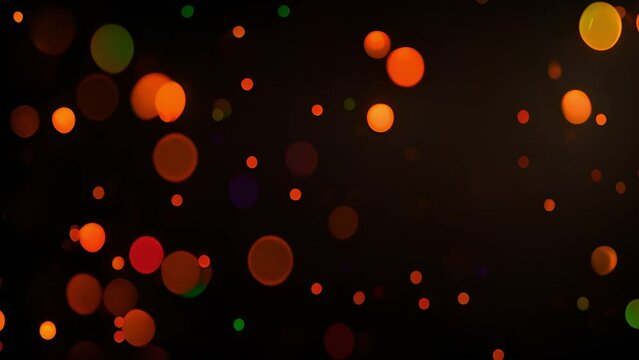 Bright colorful abstract bokeh circles moving around. Green,orange and red design. Abstract colorful pattern with defocused lights on black background with space for your text. contains transparencies