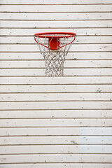 Wooden wall painted with white glaze, tongue and groove, and a hanging basketball hoop